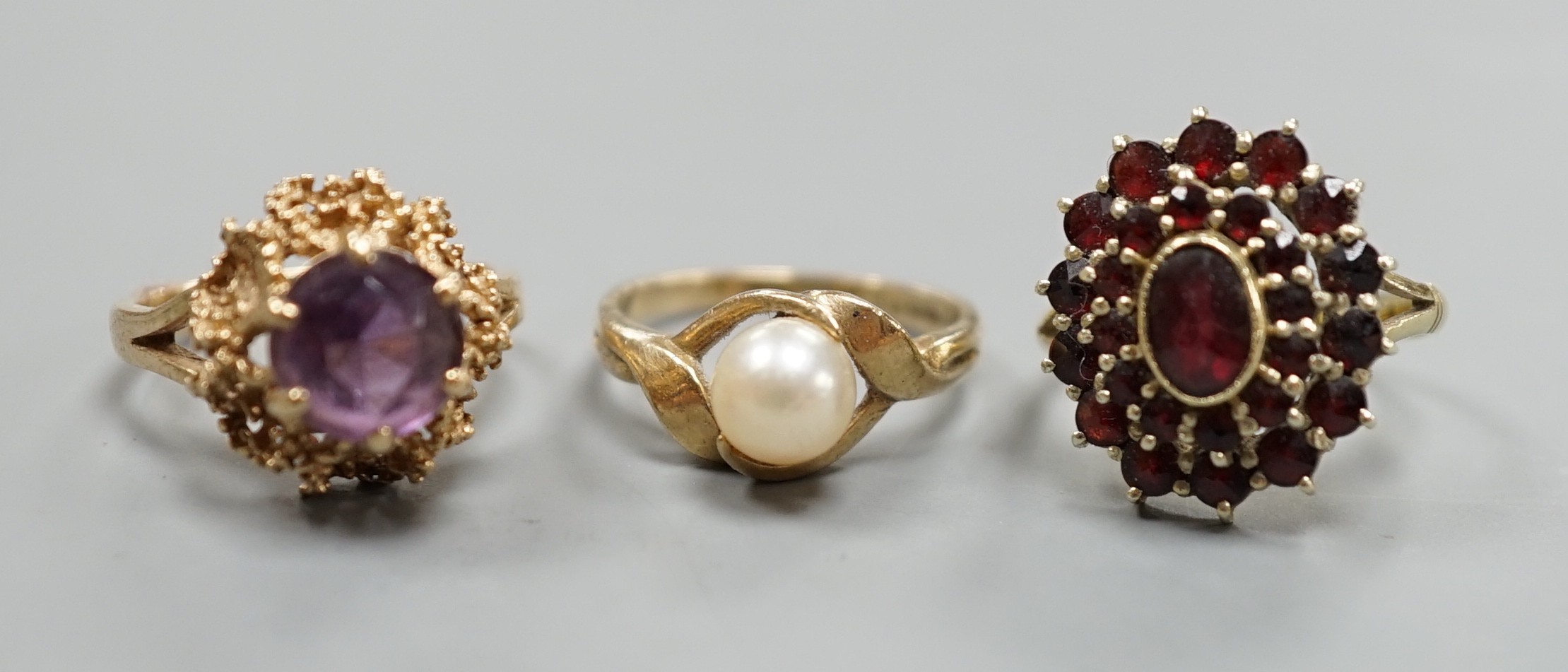 Two modern 9ct gold dress rings, one set with cultured pearl, the other with amethyst, gross weight 6.5 grams and an Austro-Hungarian yellow meta and garnet cluster ring, gross 4.4 grams.